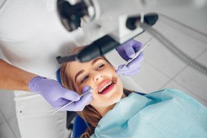 A woman is getting her teeth examined by a dentist.