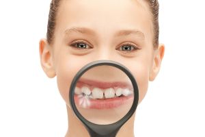 A young girl looking through a magnifying glass.