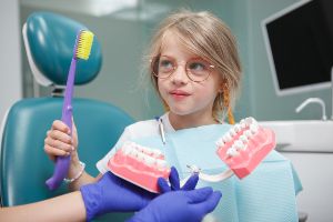 A little girl is sitting in a dentist's chair.