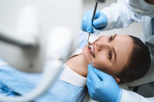 A woman is getting her teeth cleaned by a dentist.