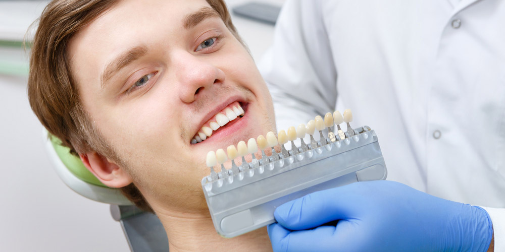 A man is getting his teeth cleaned by a dentist.