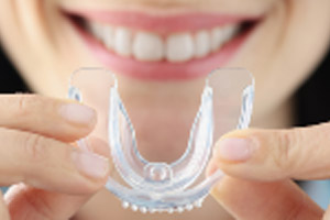 A woman holding up a clear braces.