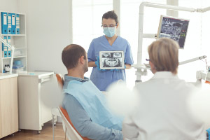 A dentist is showing a patient an x-ray.