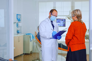 A group of people in a dental office talking to each other.