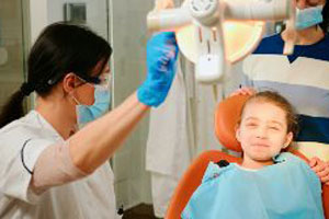 A young girl is being examined by a dentist.