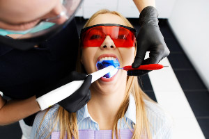 A woman is getting her teeth cleaned by a dentist.