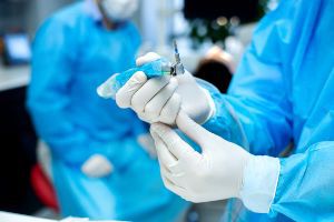 A dentist in a blue suit is working on a patient.