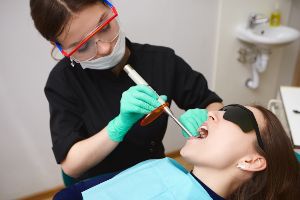 A woman is getting her teeth cleaned in a dentist's office.