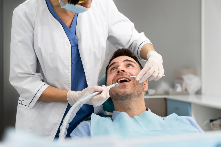 A man is getting his teeth examined by a dentist.