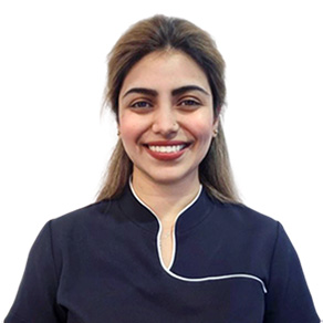 A smiling woman in a dental uniform.