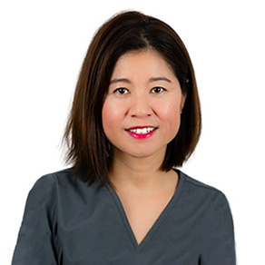 A woman in a gray shirt posing for a photo.