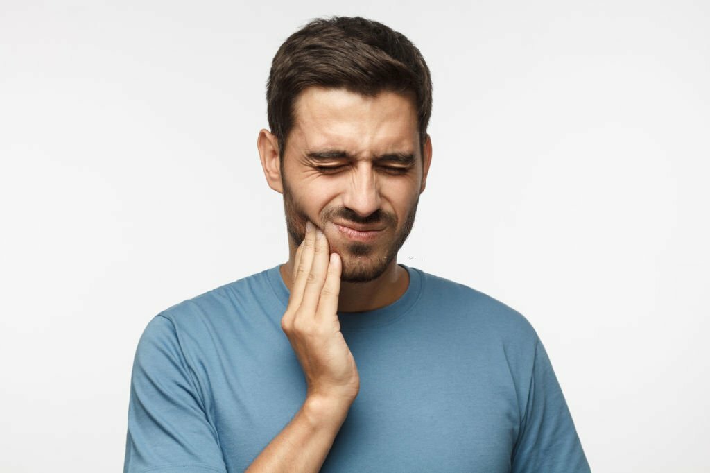 A man with a toothache holding his hand, experiencing unbearable pain.
